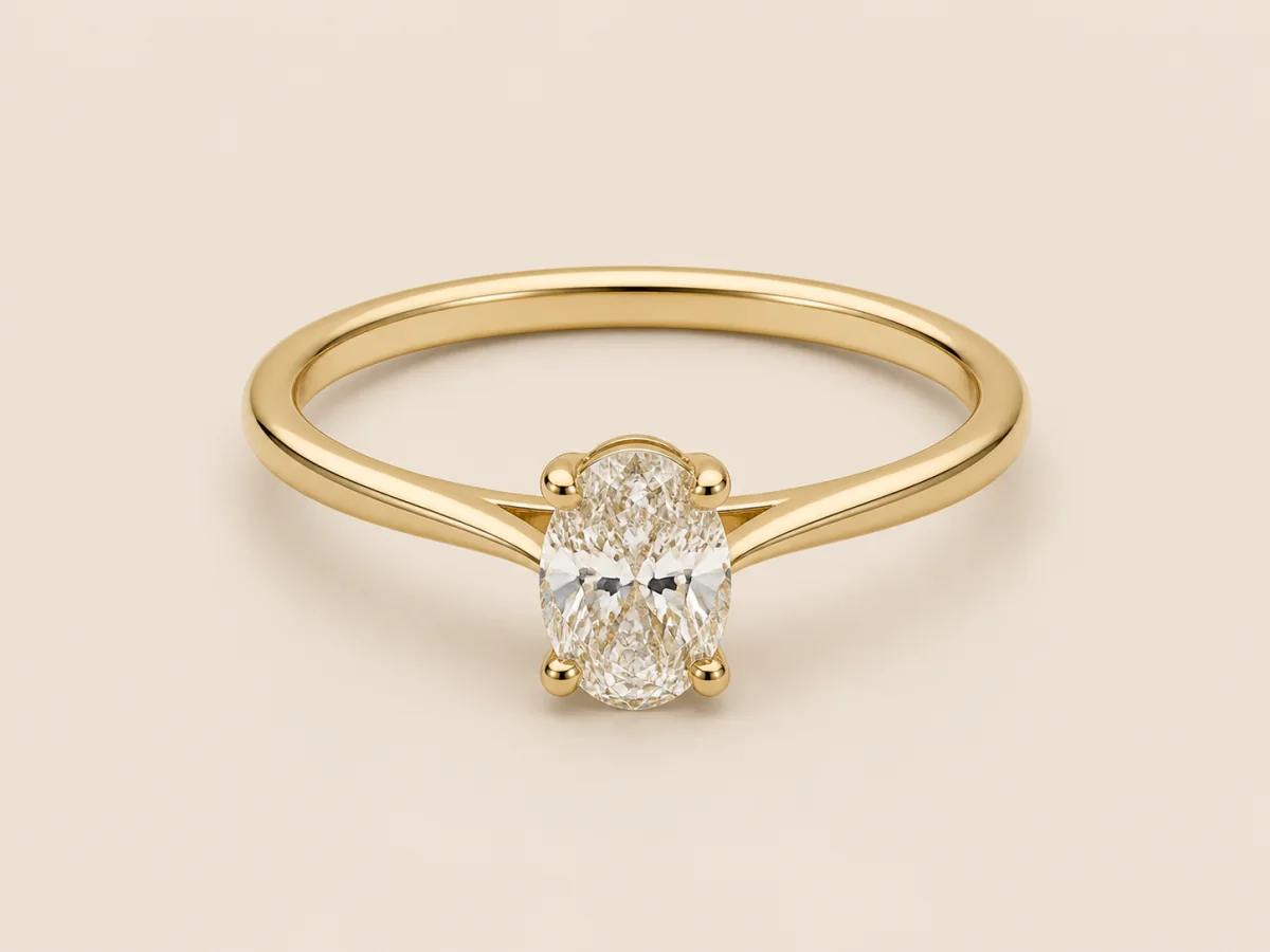 Yellow-gold oval solitaire with a slim plain band and connected four-prong setting, shown in a three-quarter product view.